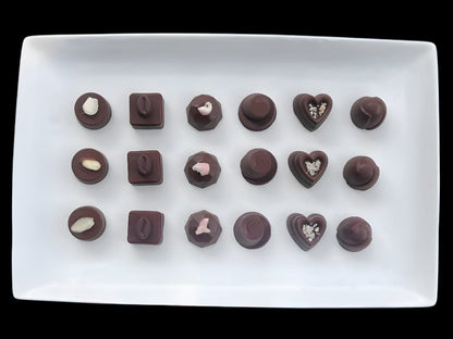 Assorted chocolate bonbons on a white rectangular plate